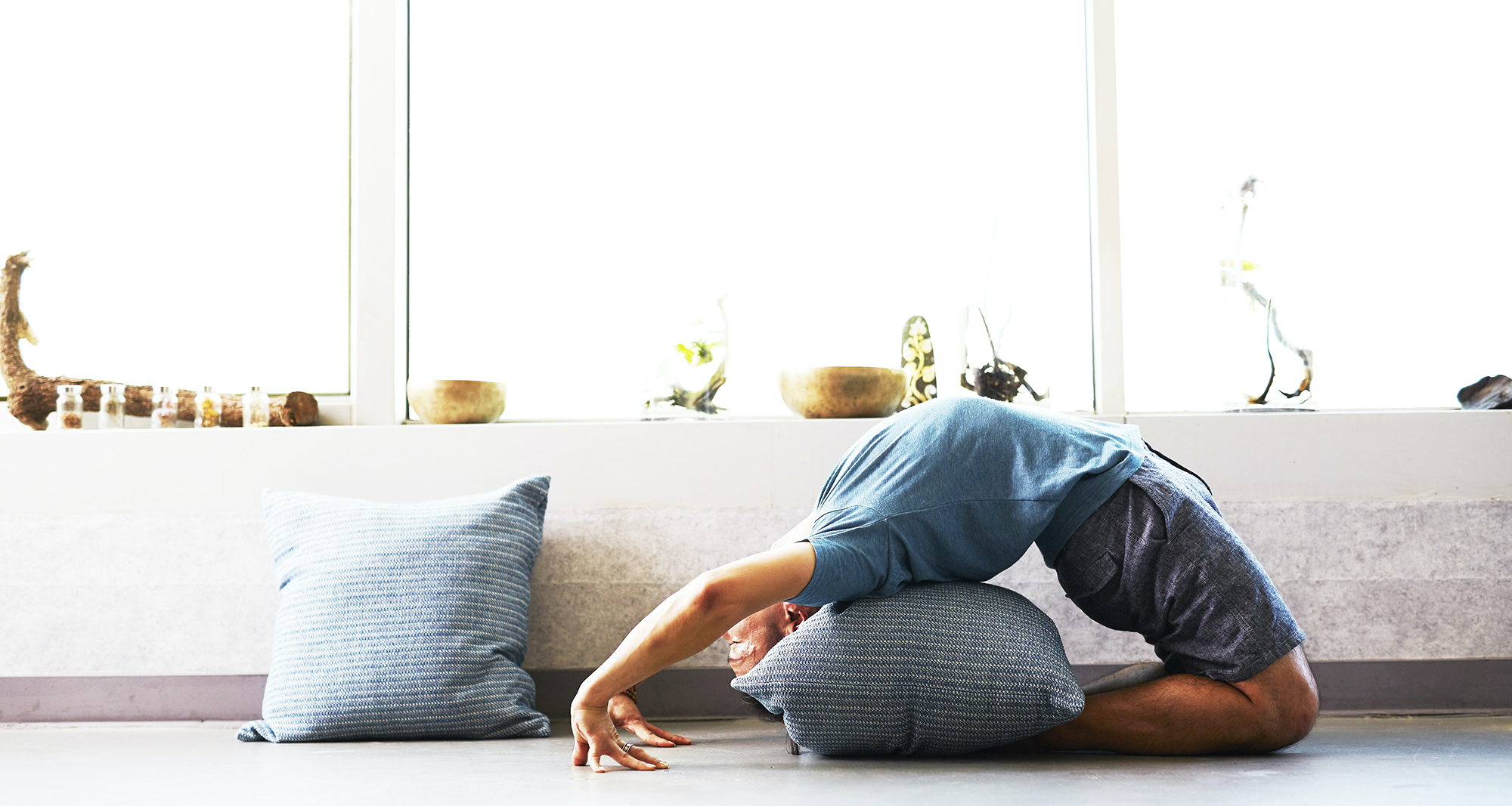 Man doing a yoga bending with pillow underneath